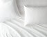 Saatva sheets and pillows on a bed. thumbnail